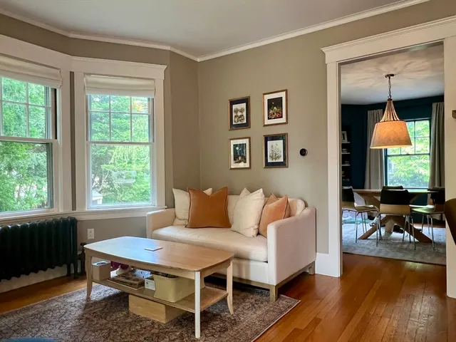 a living room with furniture a window and wooden floor