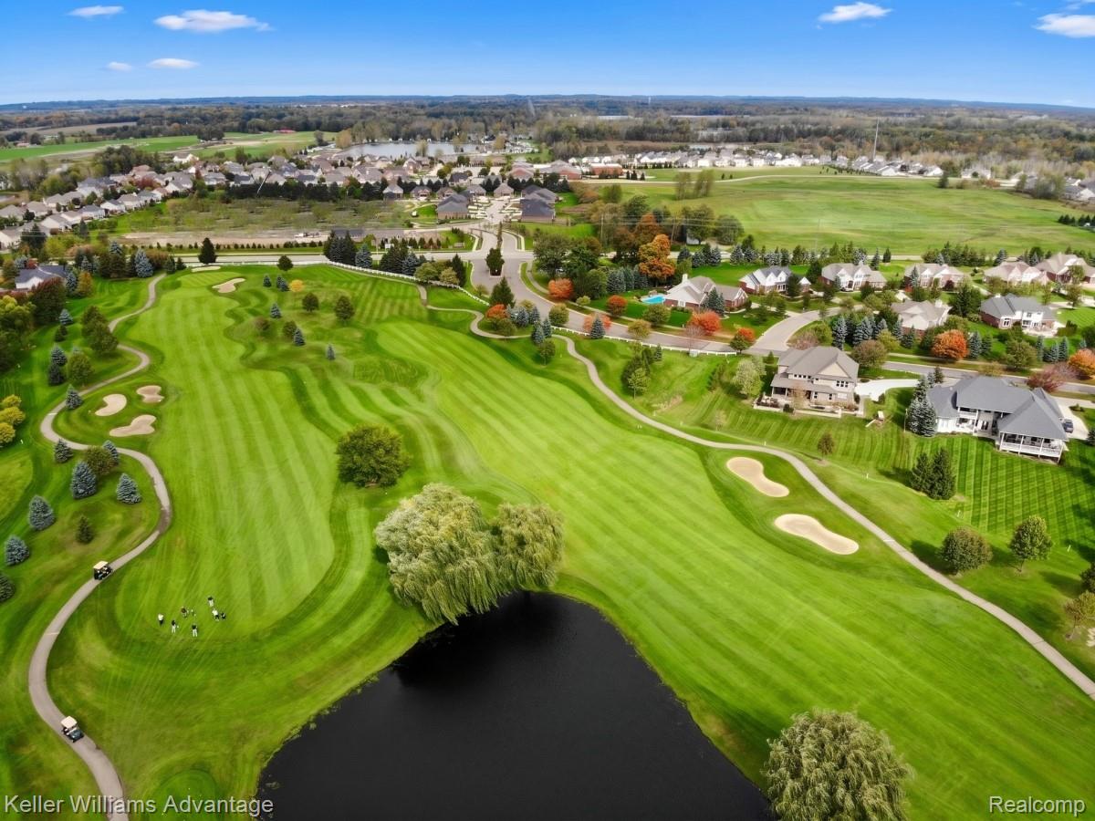 22878 Tree Top Court South Lyon, MI 48178 - Photo 67 of 75 Expansive golf course featuring manicured fairways, sand traps, and a water feature