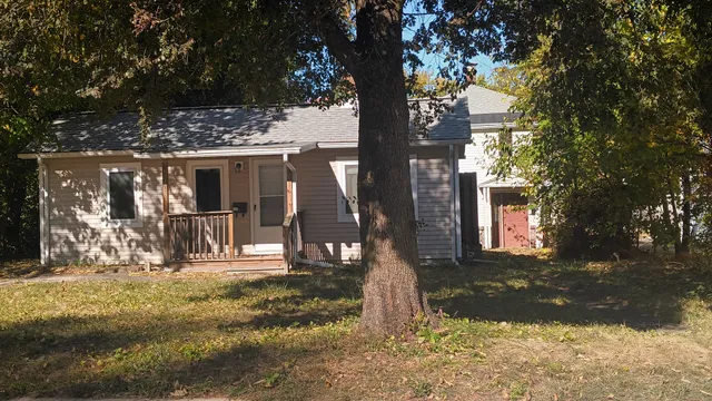 a front view of a house with a tree