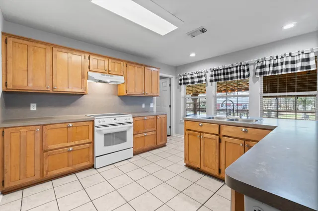 a kitchen with stainless steel appliances granite countertop a stove a sink and a microwave