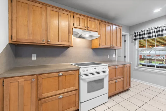 a kitchen with granite countertop white cabinets and white appliances