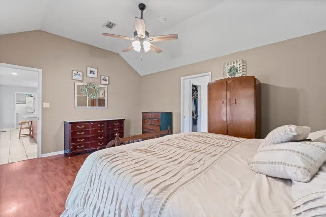 a bedroom with a large bed and chandelier