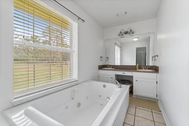 a bathroom with a tub sink and mirror