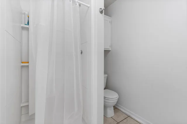a white toilet sitting next to a white wall
