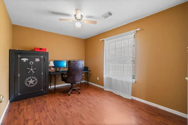 a view of a workspace with furniture and a window