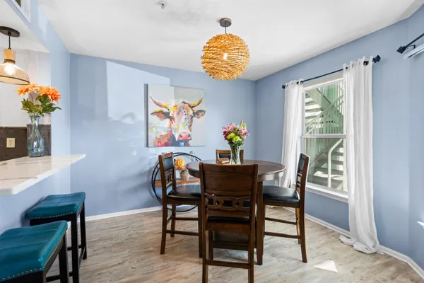a dining room filled chandelier and wooden floor