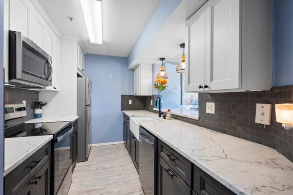 a kitchen with a sink stove top oven and cabinets