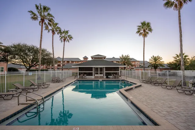 a view of a swimming pool with a yard and a patio
