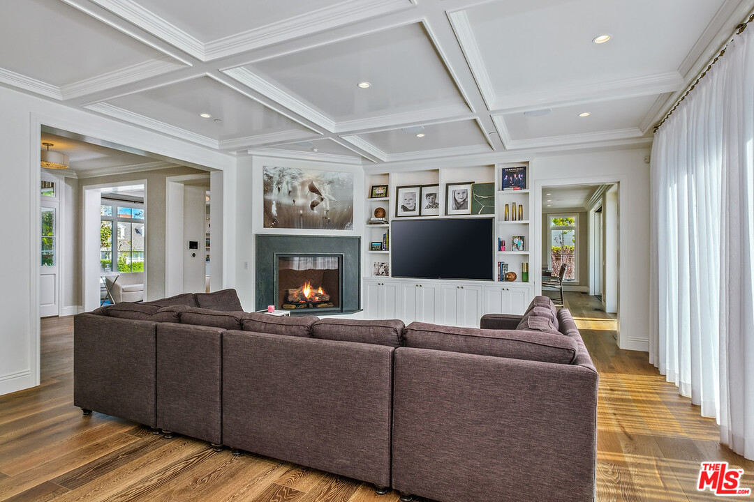 557 Chapala Drive Pacific Palisades, CA 90272 - Photo 11 of 48 a living room with furniture a flat screen tv and a fireplace