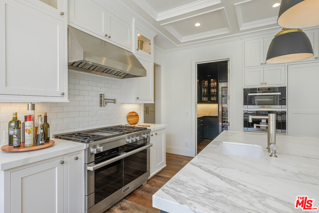 557 Chapala Drive Pacific Palisades, CA 90272 - Photo 12 of 48 a kitchen with stainless steel appliances granite countertop a stove and a refrigerator