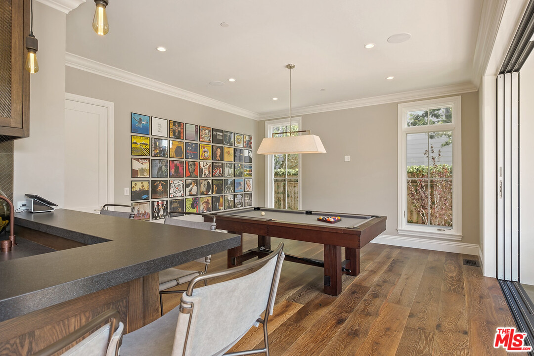 557 Chapala Drive Pacific Palisades, CA 90272 - Photo 19 of 48 a room with a table chairs and wooden floor