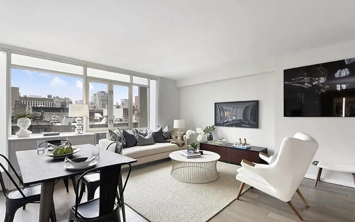 a living room with furniture a flat screen tv and a floor to ceiling window