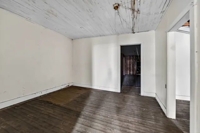 a view of a room with wooden floor and door