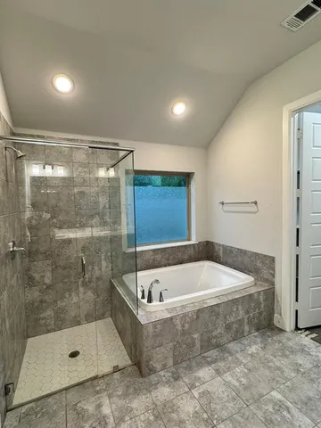 a bathroom with a bath tub and shower