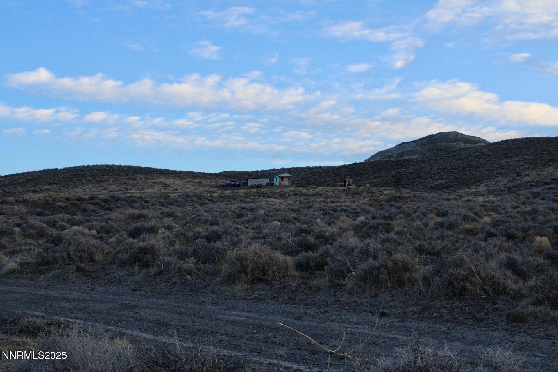 7785 Desert Shadows Lane Fernley, NV 89408 - Photo 15 of 21 a view of a dry yard with mountains in the background
