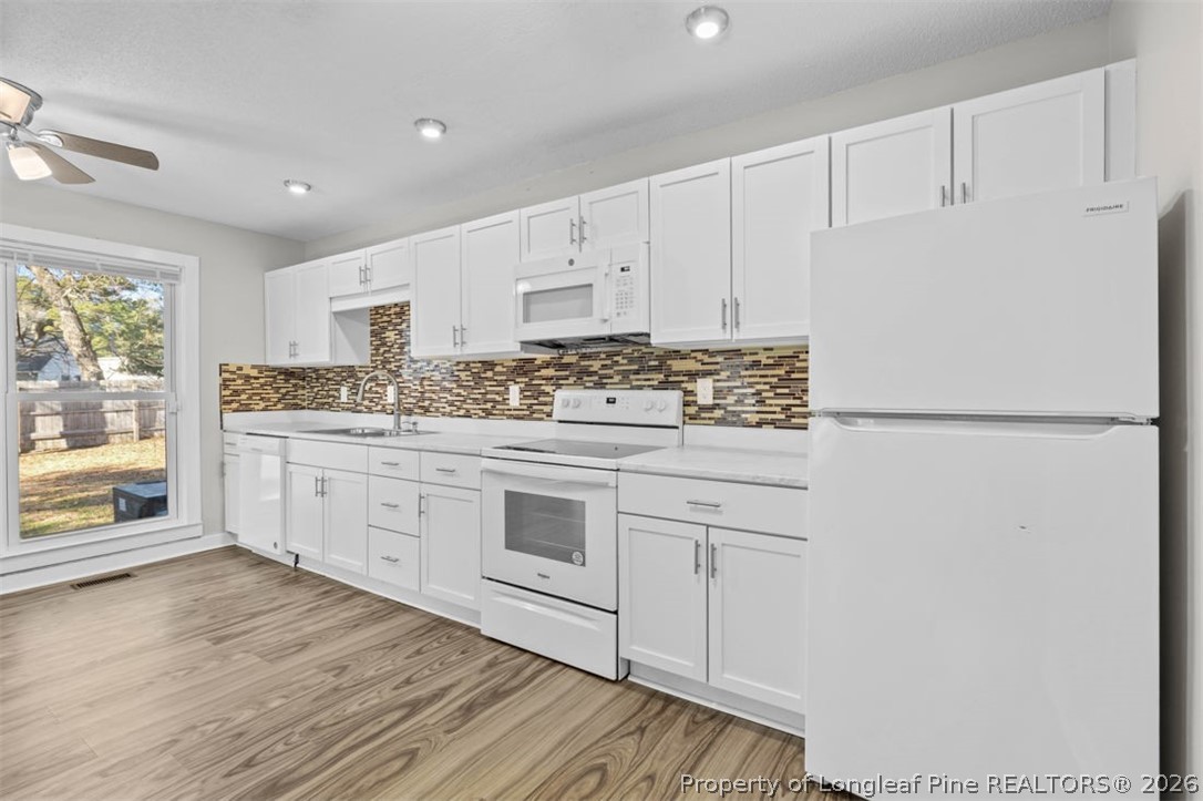 3305 Hunting Bay Drive Spring Lake, NC 28390 - Photo 12 of 27 a kitchen with stainless steel appliances granite countertop a stove a sink and white cabinets