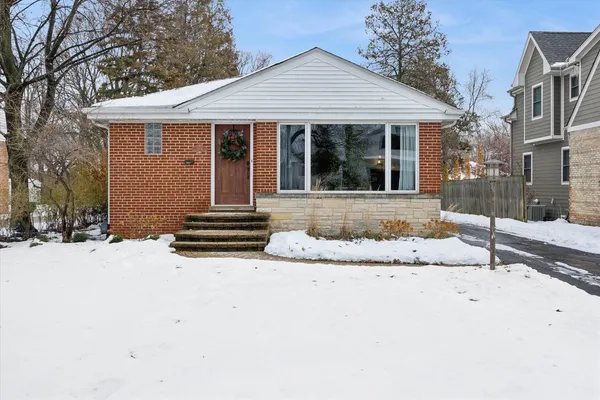 a front view of a house with a yard covered in snow