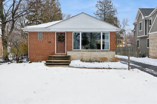 a front view of a house with a yard covered in snow