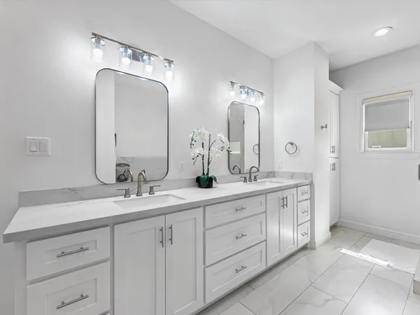 a bathroom with a granite countertop sink a mirror and shower
