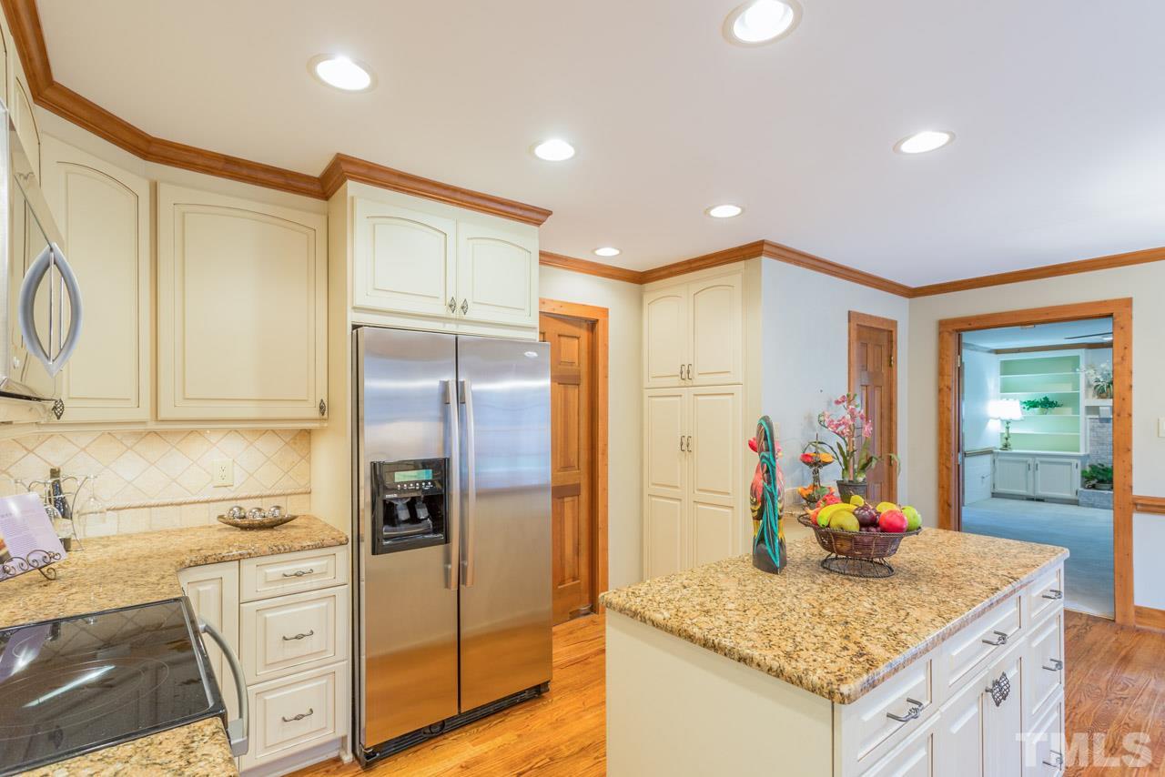 10405 Boxelder Drive Raleigh, NC 27613 - Photo 2 of 25 Granite counters, tile backsplash, under cabinet lighting, center island. Pantry closet and cabinet pantry, beautiful cabinets.