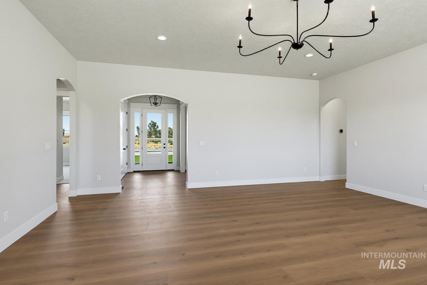 5054 Heritage Drive Marsing, ID 83639 - Photo 11 of 38 Spacious room featuring wood-finish flooring, white baseboards, and neutral wall paint