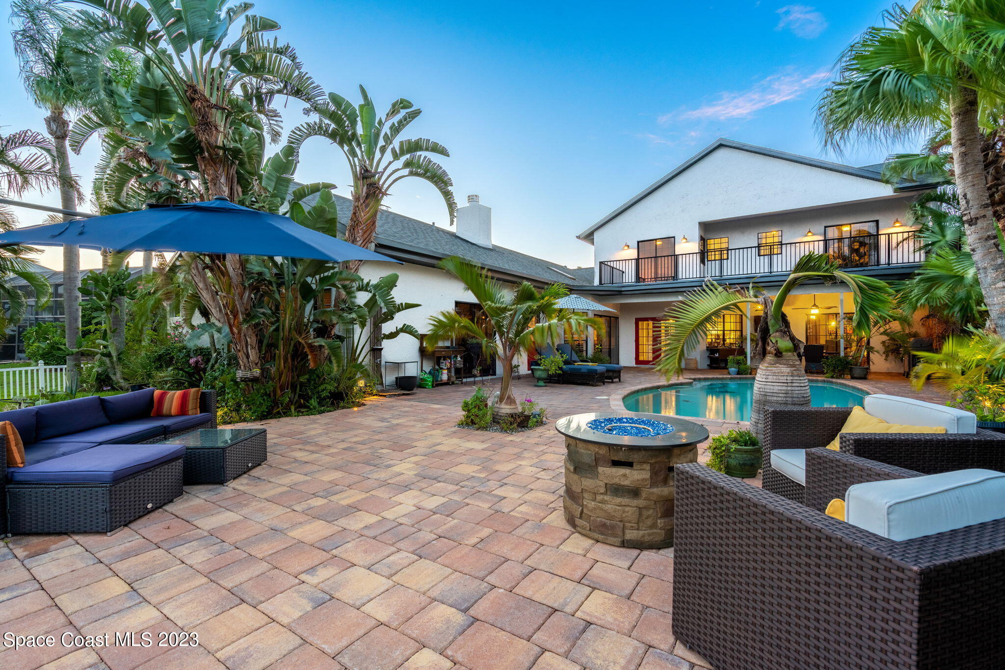 70 Lanternback Island Drive Satellite Beach, FL 32937 - Photo 19 of 26 a patio area with table and chairs under an umbrella