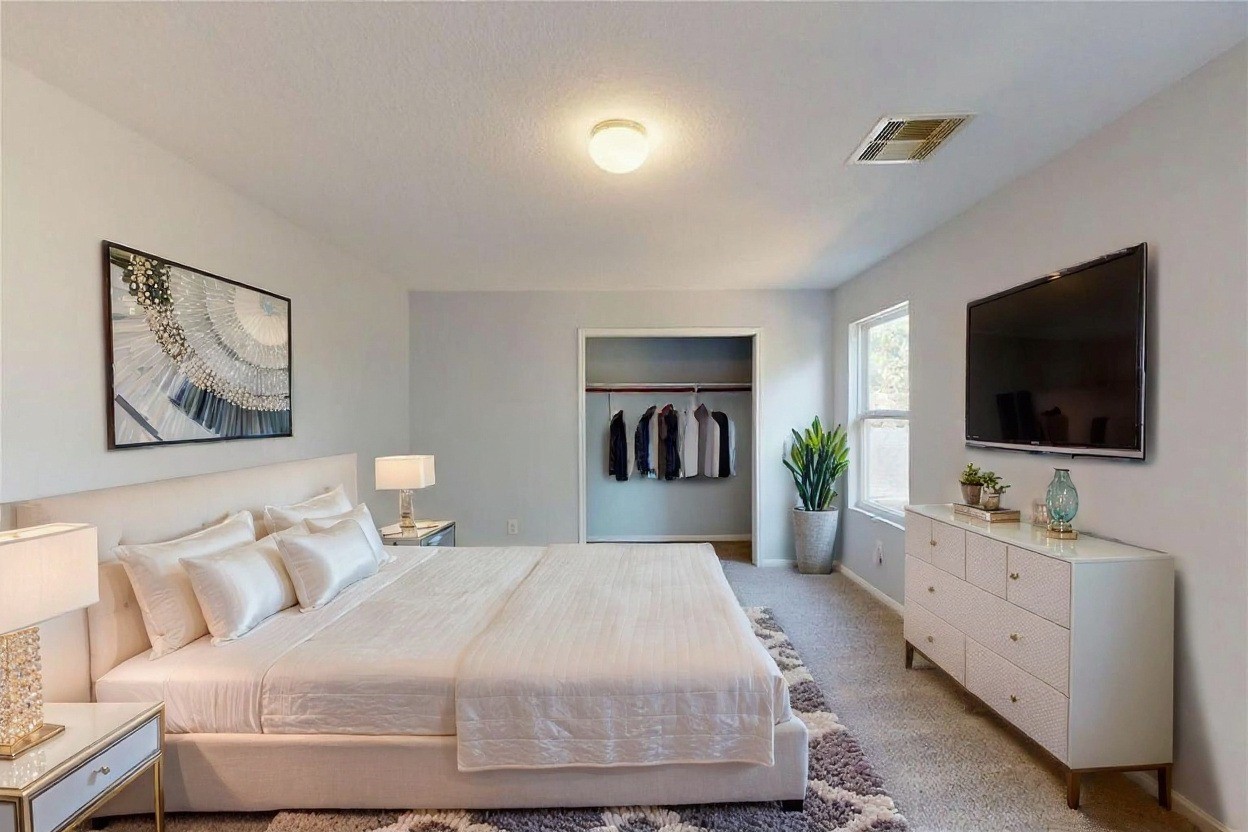 9877 Lace Flower Way Conroe, TX 77385 - Photo 28 of 43 a bedroom with a large bed and a flat screen tv