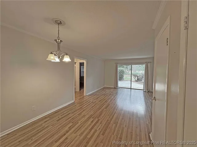 a view of empty room with wooden floor and window
