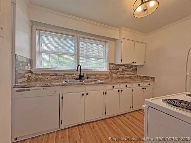 a kitchen with granite countertop white cabinets and white appliances