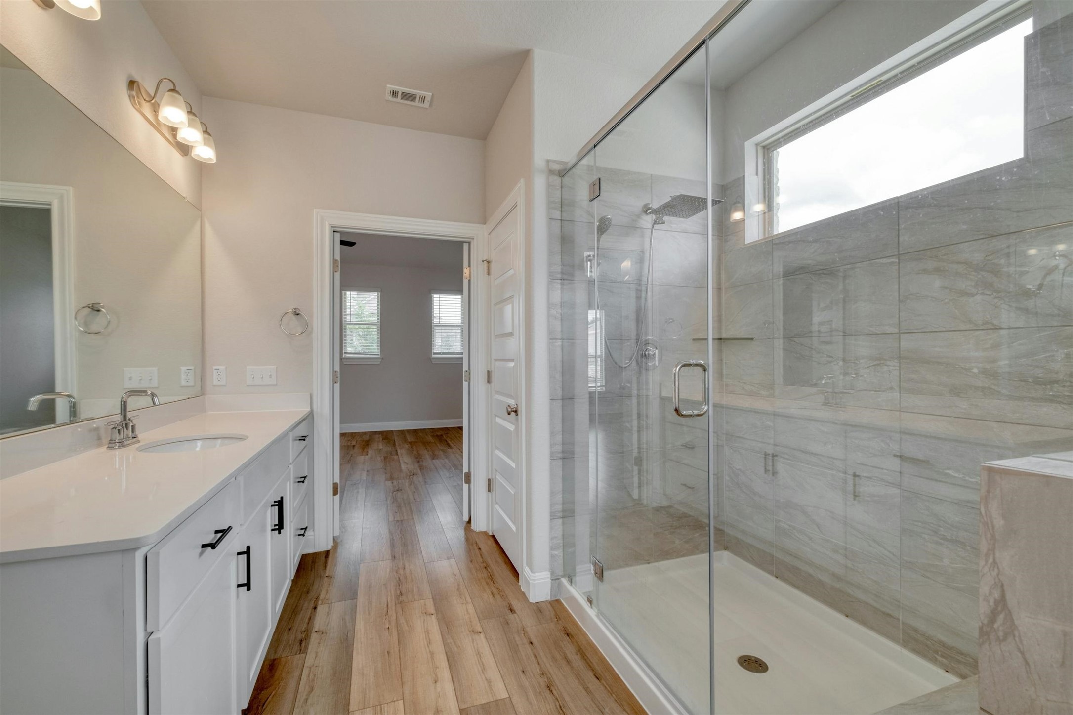 228 Rieber Road Kyle, TX 78640 - Photo 13 of 27 a bathroom with a granite countertop sink a mirror a bathtub and shower