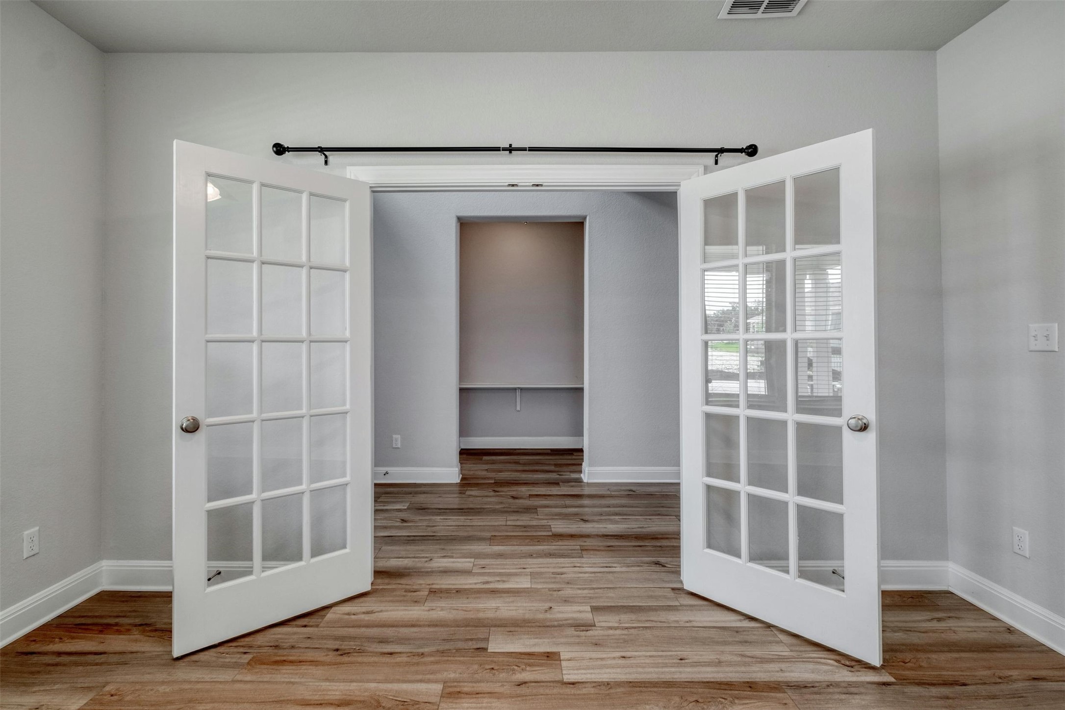 228 Rieber Road Kyle, TX 78640 - Photo 10 of 27 a view of an empty room with wooden floor and a window