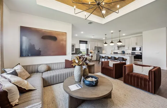 a living room with furniture a flat screen tv and a large window