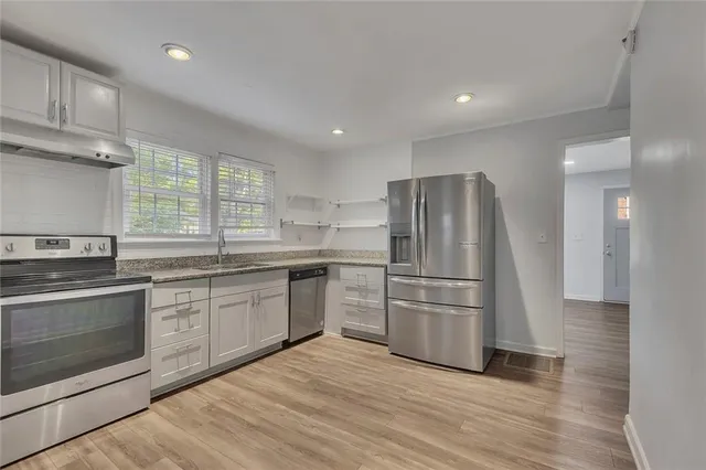 a kitchen with granite countertop stainless steel appliances a refrigerator sink and microwave