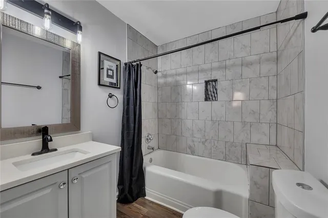 a bathroom with a sink a toilet a mirror and shower