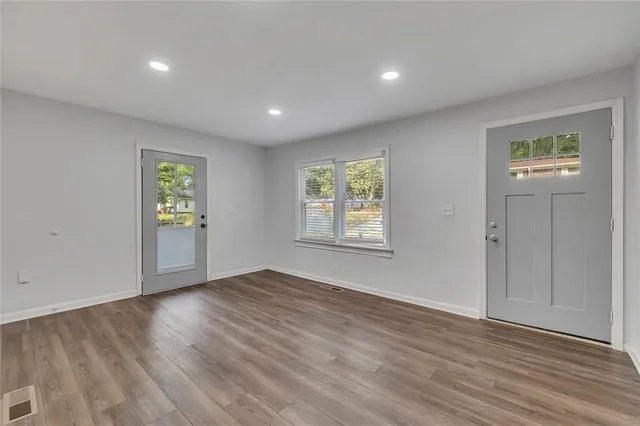 an empty room with windows and closet