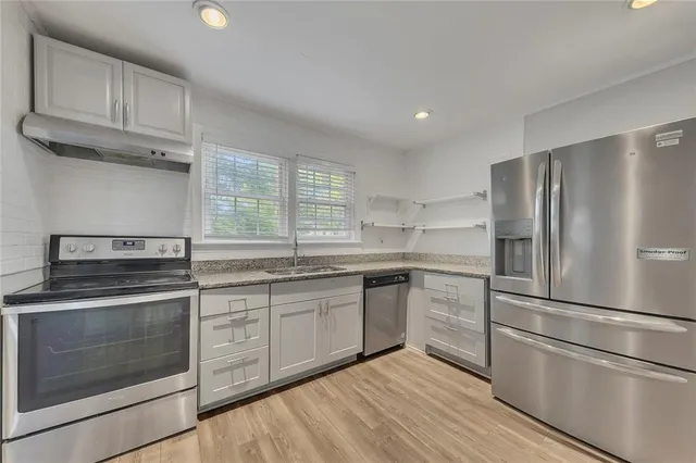 a kitchen with granite countertop stainless steel appliances and wooden cabinets