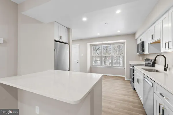 a large white kitchen with a large window