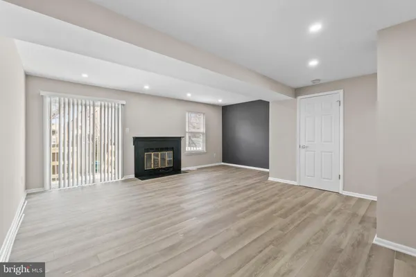a view of empty room with wooden floor and fireplace
