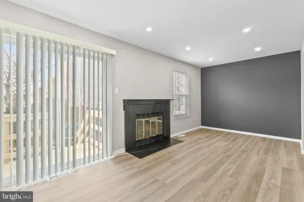 a view of an empty room with a fireplace and a window