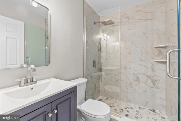 a bathroom with a sink a toilet and shower