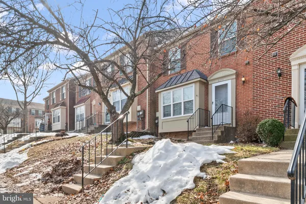 a front view of a house with a yard covered in snow