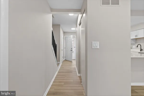 a view of a hallway with wooden floor and staircase