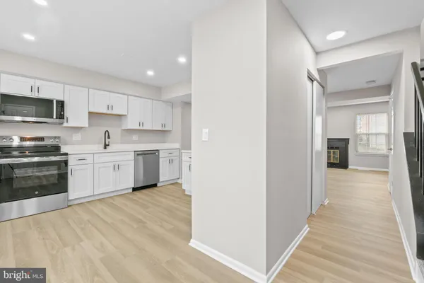a kitchen with white cabinets and stainless steel appliances