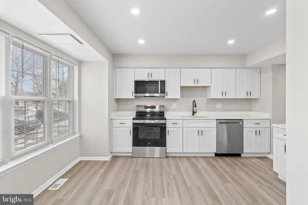 a kitchen with a stove a sink and a microwave