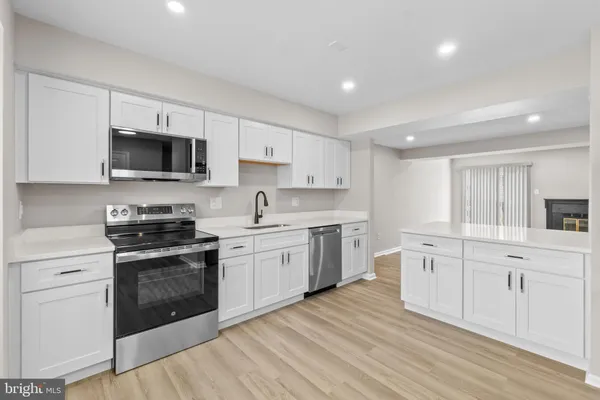 a kitchen with granite countertop a sink cabinets and stainless steel appliances