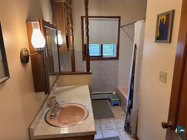 38 Locust Drive Babbitt, MN 55706 - Photo 15 of 29 Full bathroom with vanity, a baseboard heating unit, tile patterned floors, and shower / bath combo