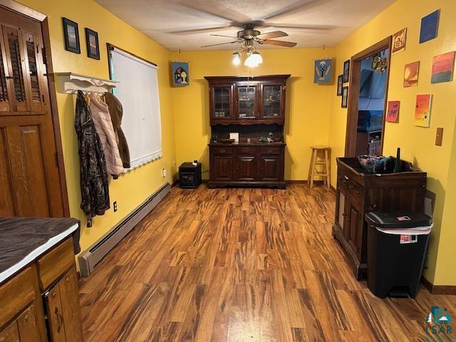 38 Locust Drive Babbitt, MN 55706 - Photo 2 of 29 Dining room featuring a baseboard heating unit, ceiling fan, dark wood-style flooring, and baseboards