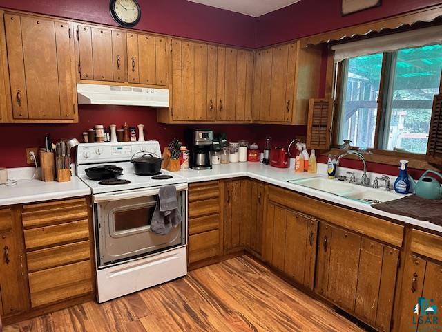 38 Locust Drive Babbitt, MN 55706 - Photo 3 of 29 Kitchen featuring under cabinet range hood, white electric range oven, and brown cabinetry