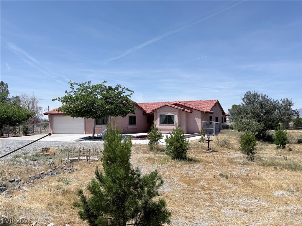 1220 East Gamebird Road Pahrump, NV 89048 - Photo 35 of 49 A terracotta-tiled roof crowns this charming home, nestled amidst a spacious, naturally landscaped lot.