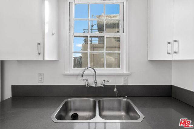 a kitchen with granite countertop white cabinets and white appliances